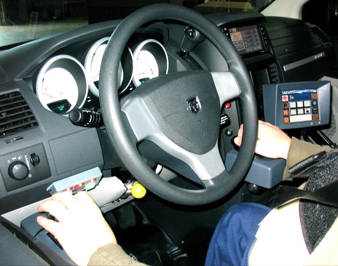 Foto de palanca electrónica de acelerador y freno para el brazo izquierdo y volante electrónico para controlar la dirección con el brazo derecho.