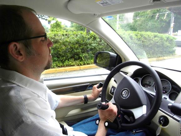 Photo of a driver using a tri-pin steering device, which allows someone without finger function to turn the steering wheel. Photos courtesy of Shepherd Center.
