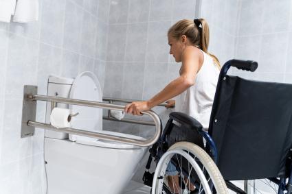 Photo of woman transferring from wheelchair to toilet