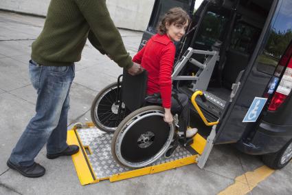 Photo of woman in wheelchair accessing a ramp into a vehicle