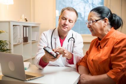 Photo of patient and clinician looking at a tablet