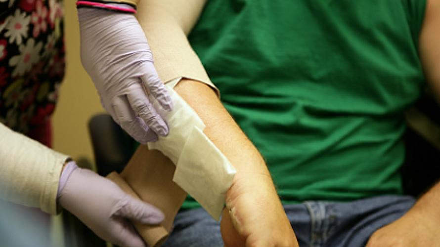 A caregiver dressing a burn on a patient's arm