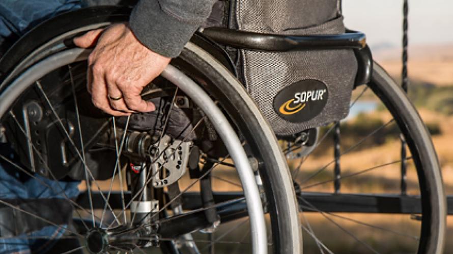 Hand resting on wheel of wheelchair