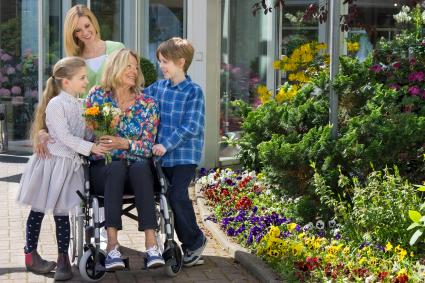 Photo of woman in wheelchair surrounded by family